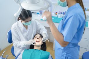 Dental assistant and dentist with a patient during a dental cleaning. 