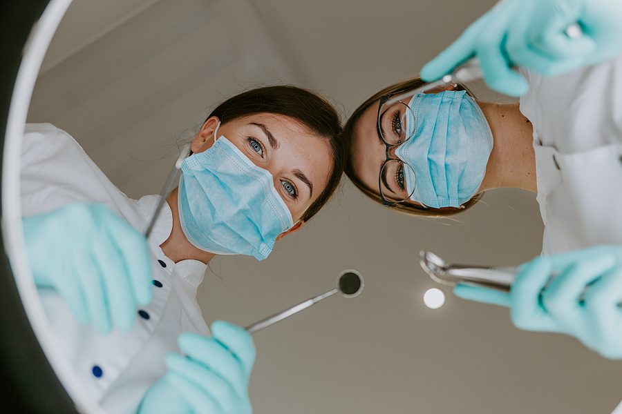 Dentist and dental assistant from a patient's point of view from the dental treatment chair.