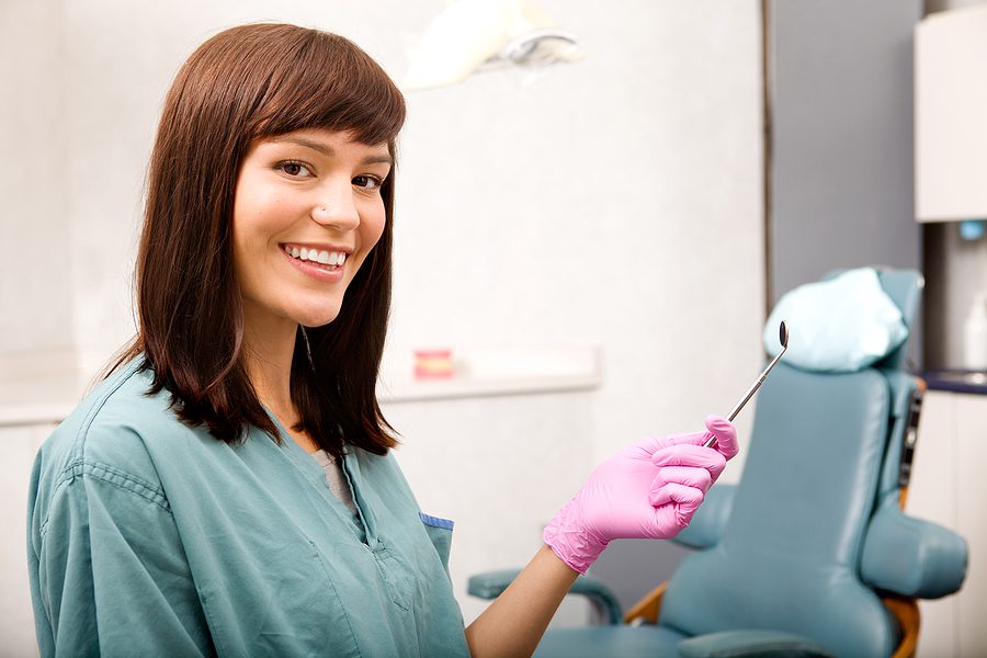 A dental assistant smiling at the camera.